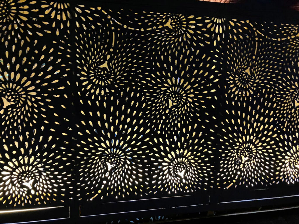 a decorative perforated metal screen with a repeating pattern